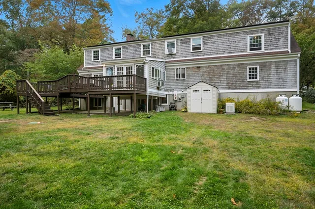a view of a house with a big yard and large trees