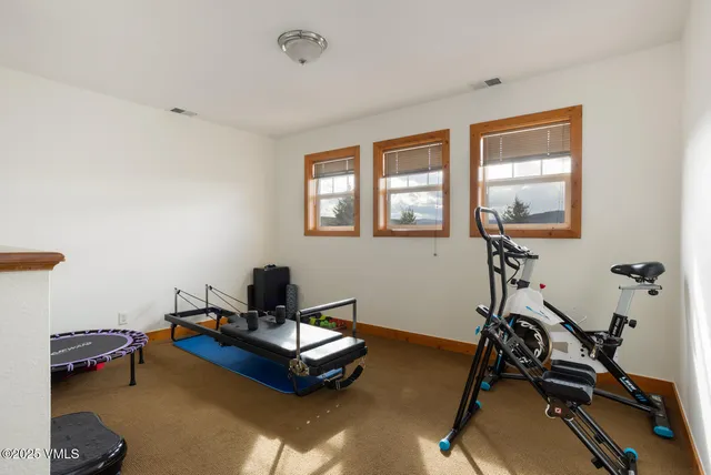 a living room with furniture gym equipment and a window