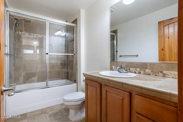 a bathroom with a granite countertop sink toilet and shower