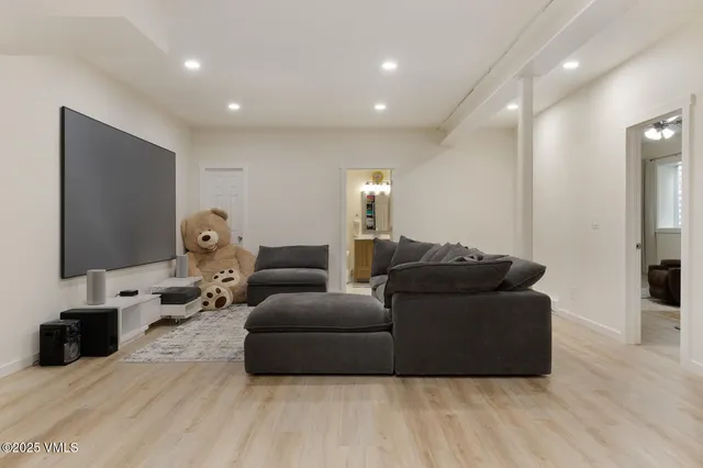 a living room with furniture a flat screen tv and a lamp