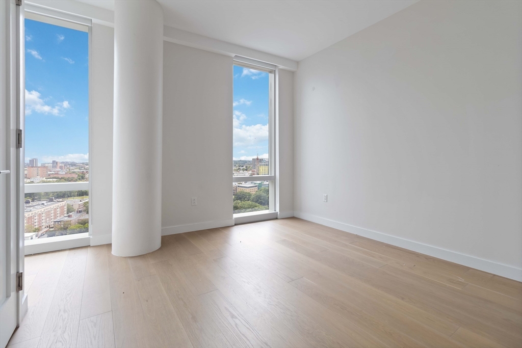 188 Brookline Avenue, Unit 20J Boston, MA 02215 - Photo 12 of 28 a view of an empty room with wooden floor and a window