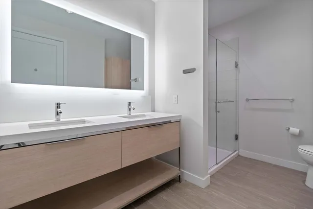 a bathroom with a double vanity sink toilet and shower