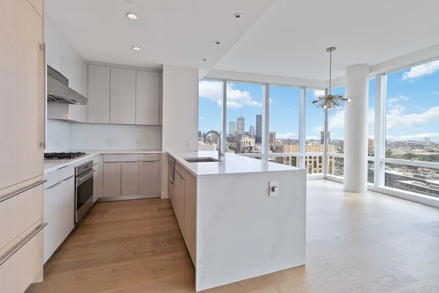 a kitchen with a sink a counter top space stainless steel appliances and cabinets