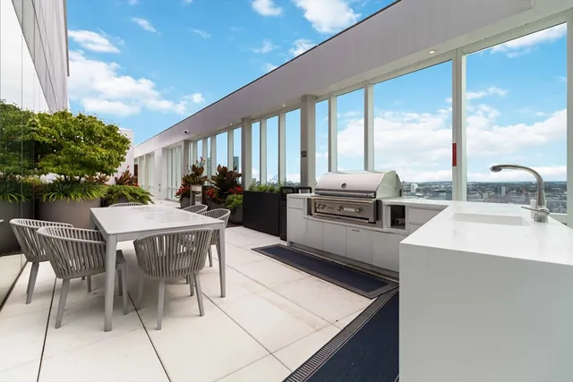 a kitchen with a stove a sink a kitchen island a table and chairs