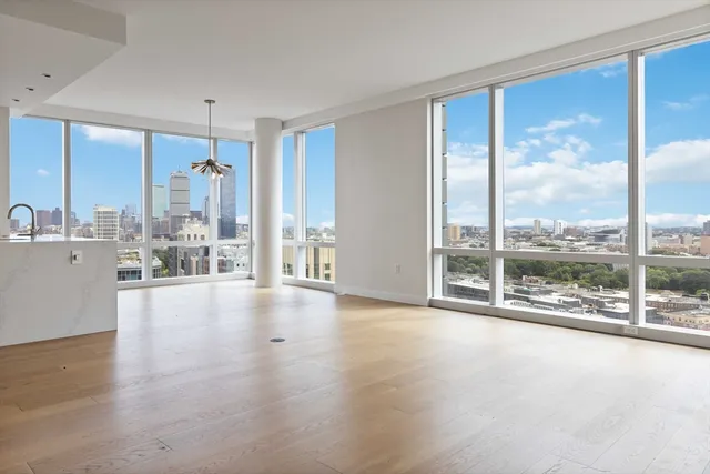 a view of an empty room with wooden floor and a floor to ceiling window
