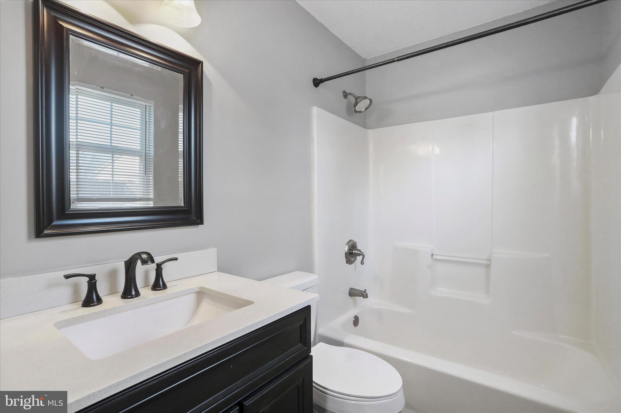 137 Woodrow Road Winchester, VA 22602 - Photo 12 of 45 a bathroom with a granite countertop sink toilet a mirror and shower