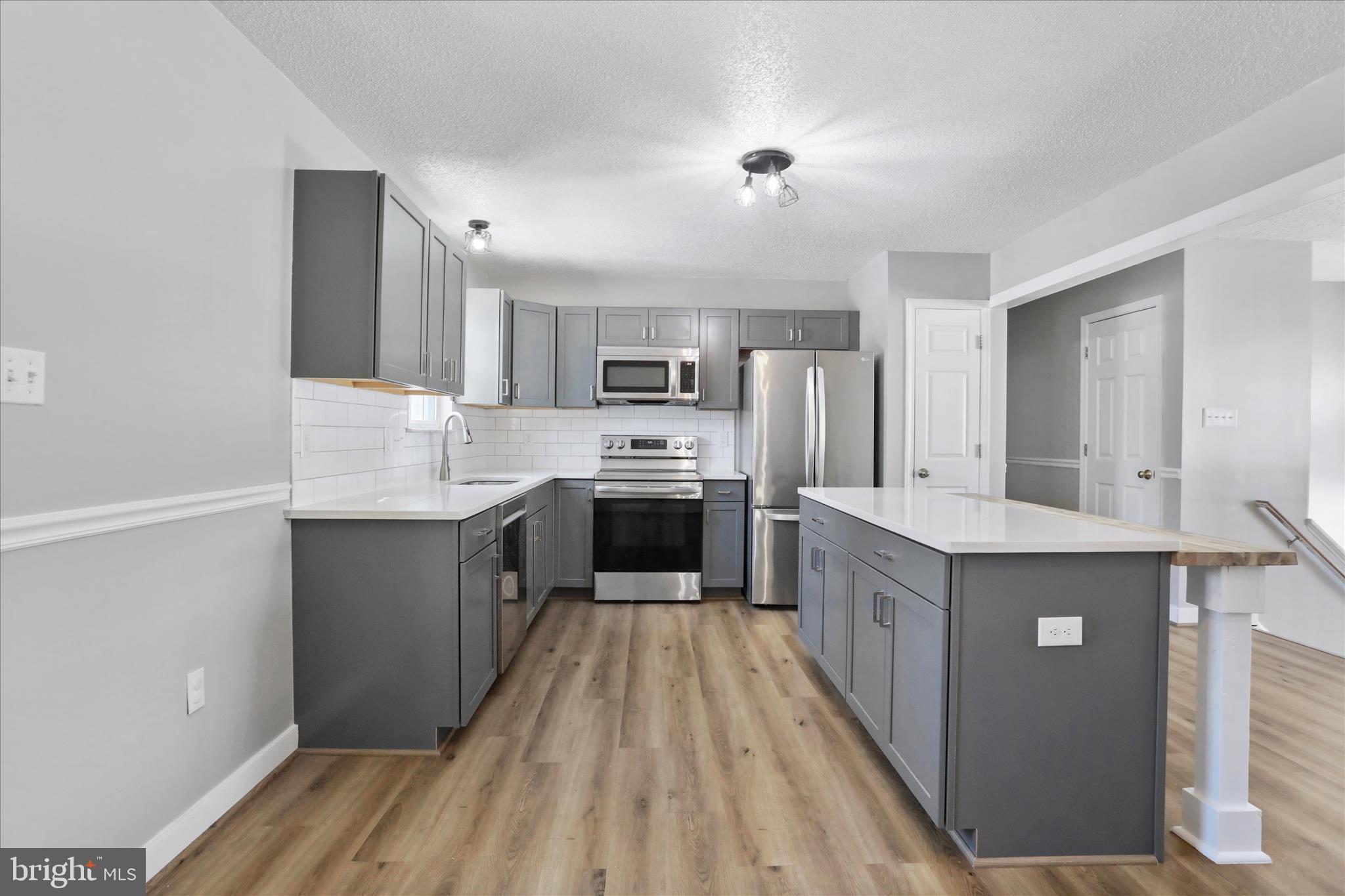 137 Woodrow Road Winchester, VA 22602 - Photo 15 of 45 a large kitchen with a center island and stainless steel appliances