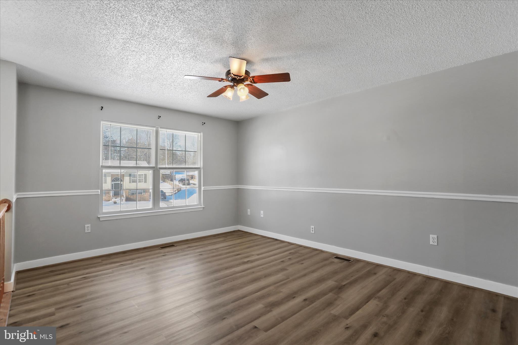 137 Woodrow Road Winchester, VA 22602 - Photo 21 of 45 an empty room with wooden floor ceiling fan and windows