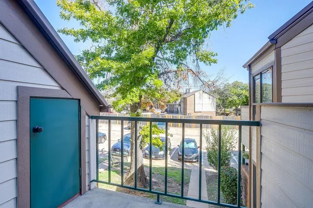 a view of a house with a large window and wooden fence