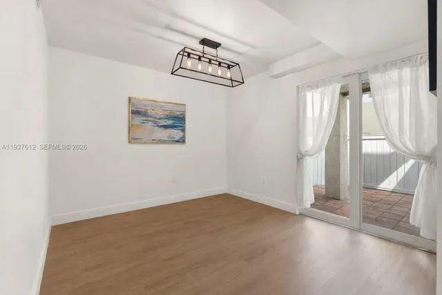 an empty room with wooden floor and entrance