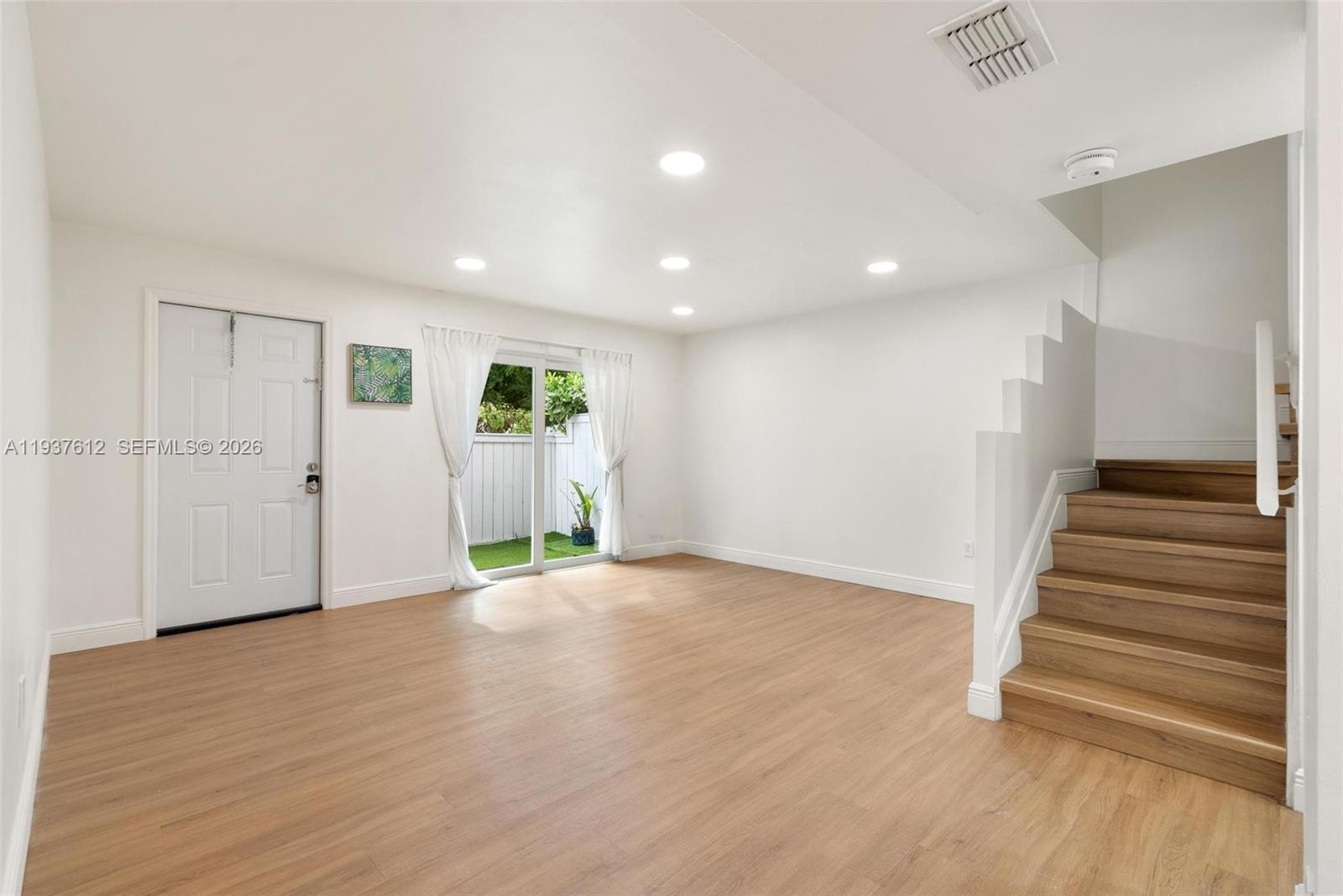 6830 Southwest 45th Lane, Unit 2 Miami, FL 33155 - Photo 17 of 21 a view of an empty room with wooden floor and entryway