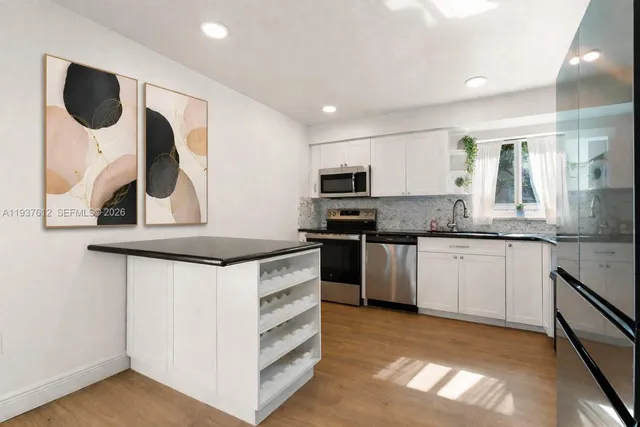 a kitchen with stainless steel appliances granite countertop a stove a sink and a microwave