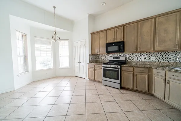 a kitchen with a stove a sink and a microwave