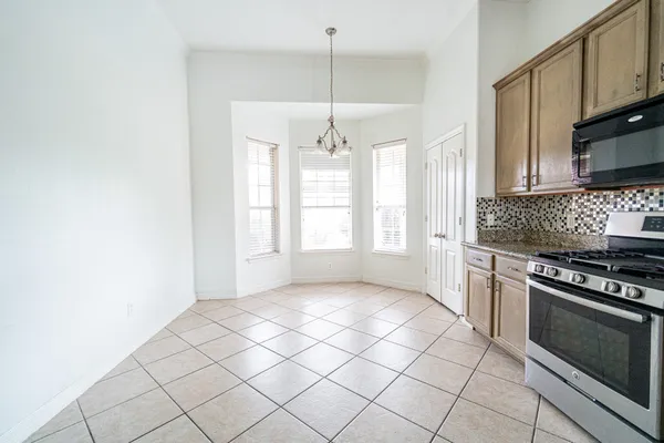 a kitchen with granite countertop a stove cabinets and a window