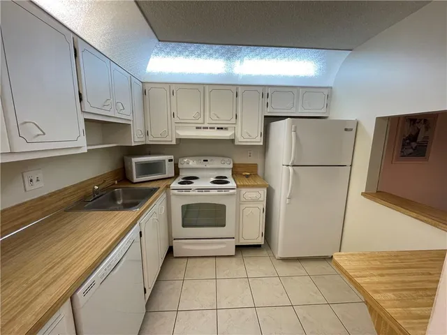 a kitchen with a white stove top oven and refrigerator