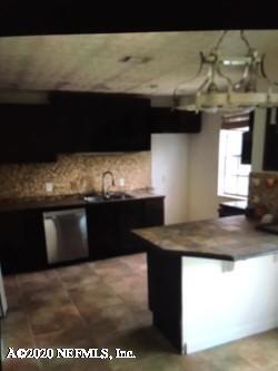 4823 Windrush Lane, Unit C3F Jacksonville, FL 32217 - Photo 5 of 9 a kitchen with a sink and a refrigerator