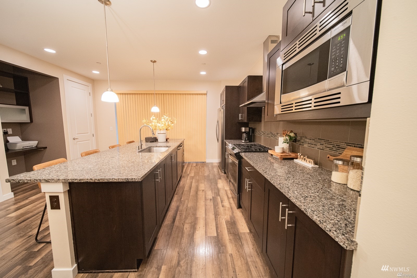 870 Southwest 96th Place Seattle, WA 98106 - Photo 12 of 27 a kitchen with kitchen island granite countertop a sink and a stove