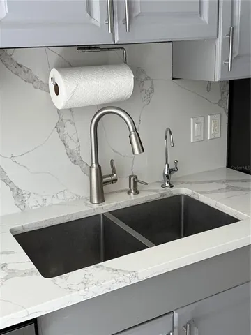 a kitchen with granite countertop white cabinets and stainless steel appliances