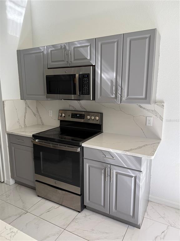 4688 Heather Terrace North Port, FL 34286 - Photo 12 of 35 a kitchen with granite countertop white cabinets and stainless steel appliances