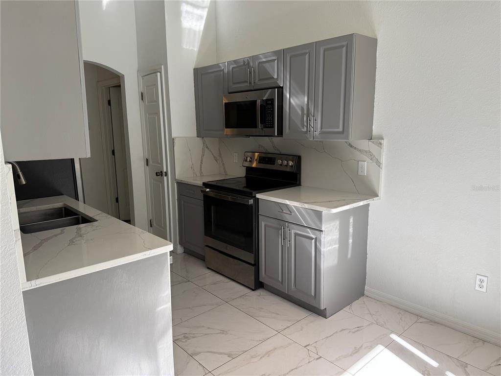 4688 Heather Terrace North Port, FL 34286 - Photo 16 of 35 a kitchen with a stove and a microwave