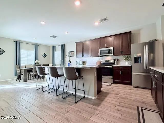 a kitchen with stainless steel appliances kitchen island granite countertop a refrigerator and a stove top oven