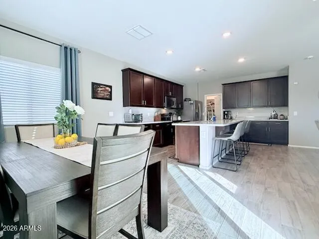 a kitchen with stainless steel appliances granite countertop sink microwave refrigerator and chairs