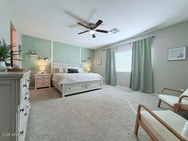 a spacious bedroom with a bed and a chandelier