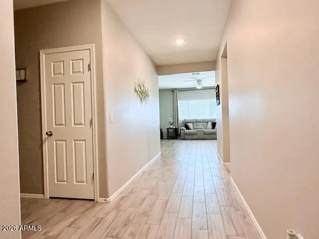 a view of a hallway with wooden floor and closet