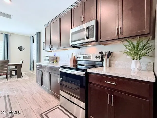 a kitchen with stainless steel appliances granite countertop a sink a stove and cabinets