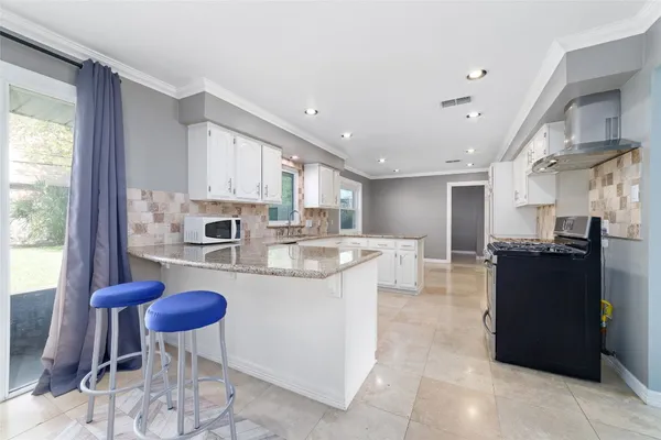 a view of a kitchen with kitchen island and stainless steel appliances