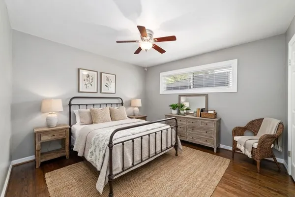 a bedroom with a bed lamp and a potted plant