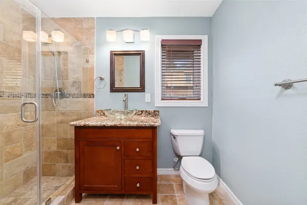 a bathroom with a sink a toilet and shower