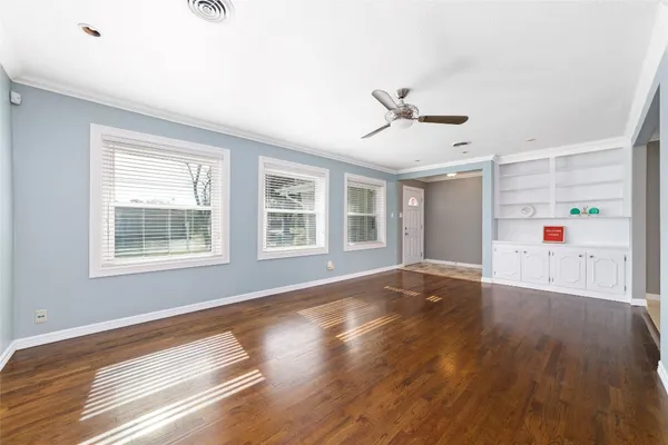 a view of livingroom with hardwood floor and a ceiling fan and window