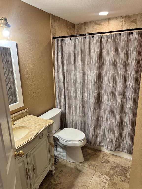 6315 Rosefinch Court, Unit 101 Lakewood Ranch, FL 34202 - Photo 14 of 30 a bathroom with a sink a toilet a mirror and shower curtain