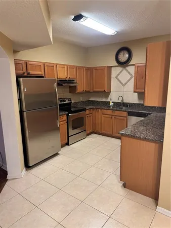 a kitchen with stainless steel appliances granite countertop a stove a refrigerator and a microwave