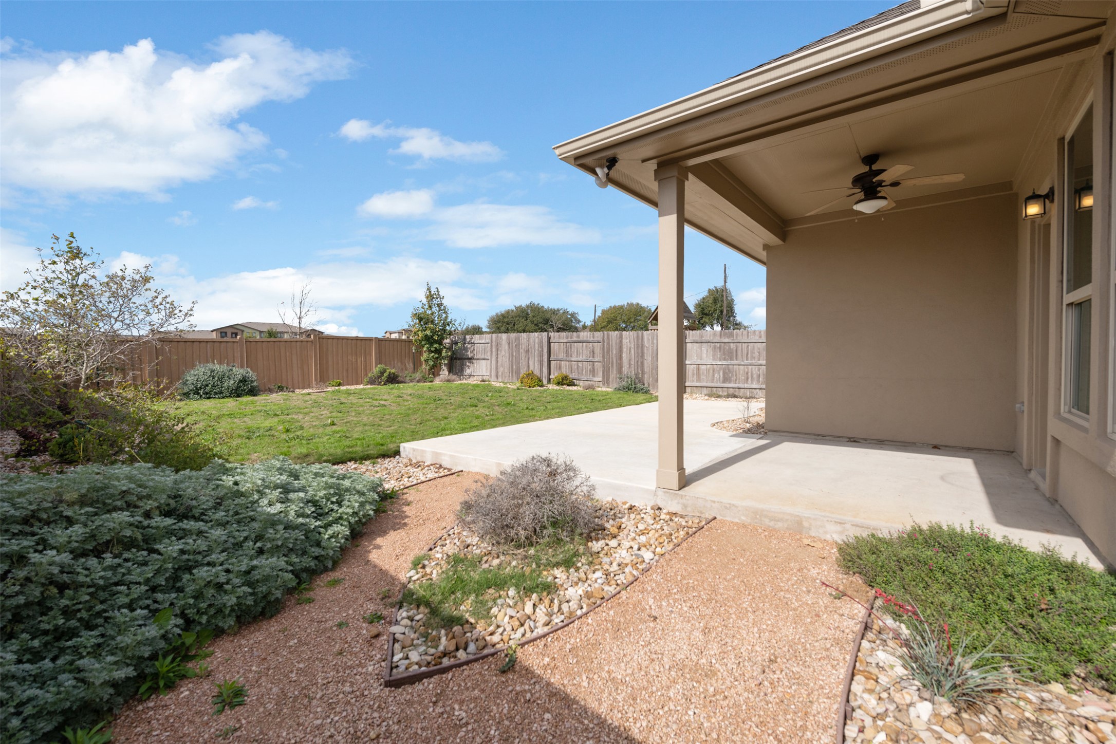 18304 Blush Rose Road Pflugerville, TX 78660 - Photo 15 of 16 A covered concrete patio overlooks a fenced backyard with established plantings.