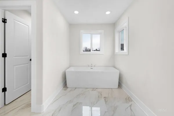 a bathroom with a white bath tub sitting next to a white sink