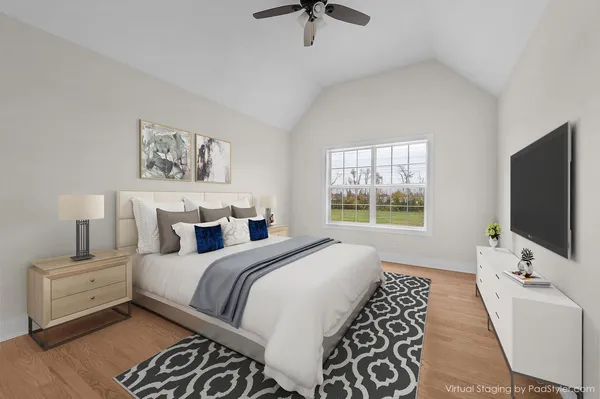a bedroom with a large bed and a flat tv screen on dresser