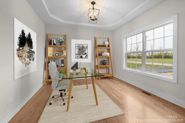 a view of a livingroom with wooden floor and furniture