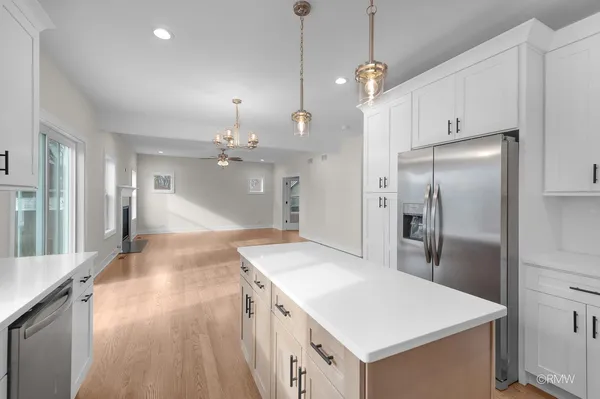 a kitchen with kitchen island white cabinets and stainless steel appliances