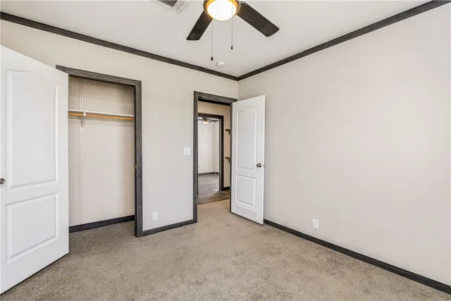 an empty room with chandelier fan