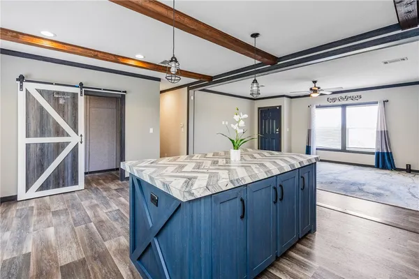 a kitchen with kitchen island granite countertop wooden cabinets and a sink