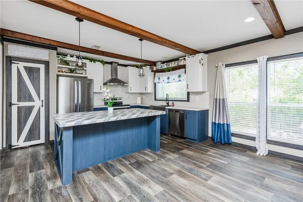 a kitchen with stainless steel appliances granite countertop a sink a stove and a refrigerator