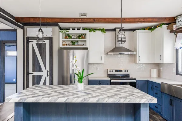 a kitchen with stainless steel appliances granite countertop a sink a stove and a wooden floors
