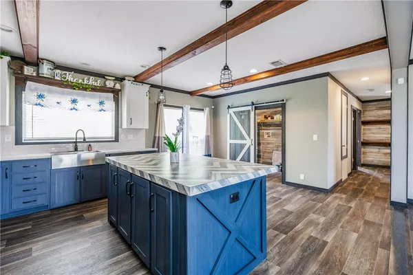 a kitchen with granite countertop a sink cabinets and wooden floor