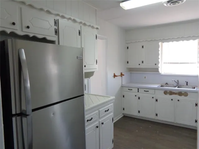 a kitchen with granite countertop cabinets and refrigerator