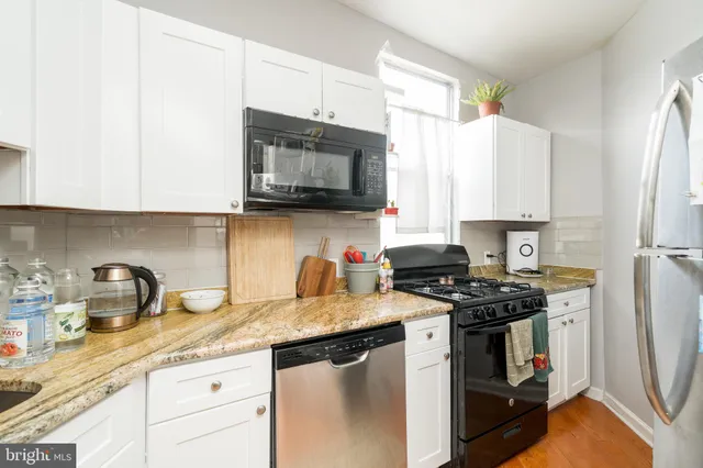 a kitchen with granite countertop a sink stainless steel appliances and cabinets
