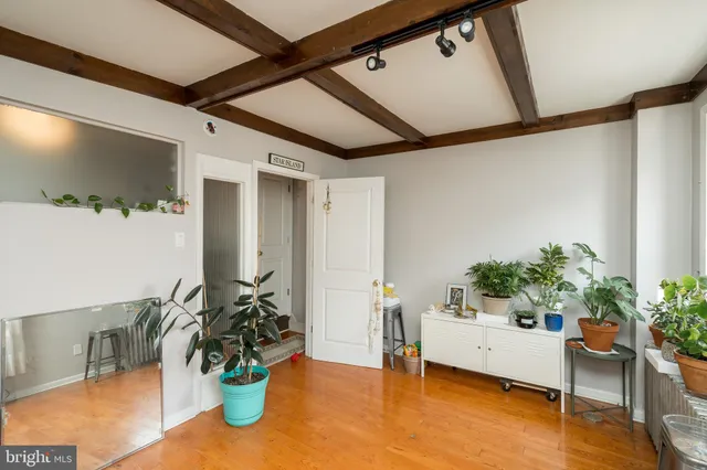 a living room with furniture kitchen view and a chandelier