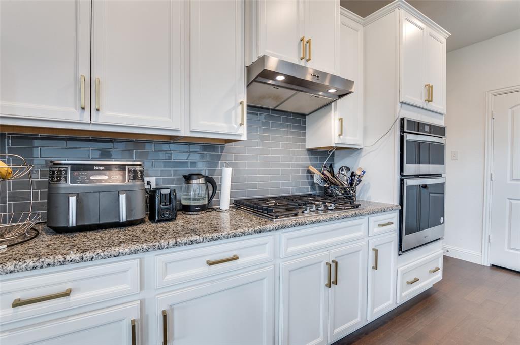1749 Wassel Road Fort Worth, TX 76052 - Photo 7 of 25 a kitchen with granite countertop stainless steel appliances a sink a stove and cabinets