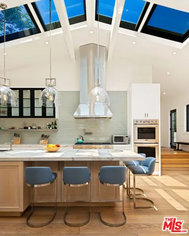 a kitchen with a stove a microwave and a dining table with wooden floor